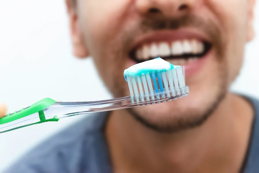 Man holding toothbrush with toothpaste